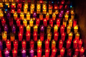 Church candles in red and yellow transparent chandeliers