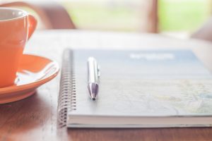 Coffee Cup With Pen And Spiral Notebook