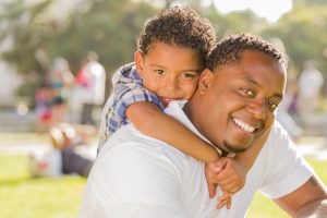 Happy African American Father and Mixed Race Son Playing Piggyba