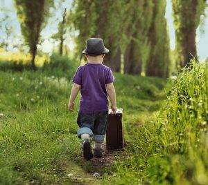 Little child carrying a suitcase