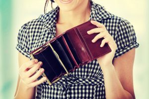 Young woman shows her empty wallet. Bankruptcy