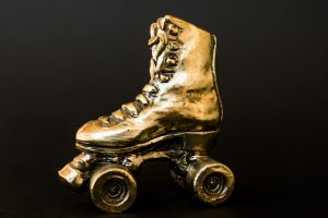 Golden Roller Skate Against Black Background